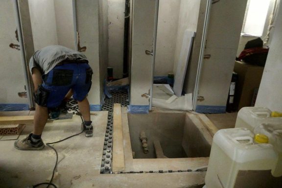 Offener Schacht hinter Bauarbeiter